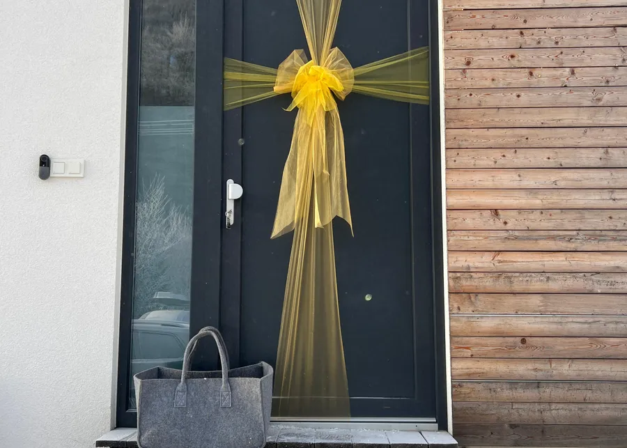 The apartment's front door with a yellow ribbon