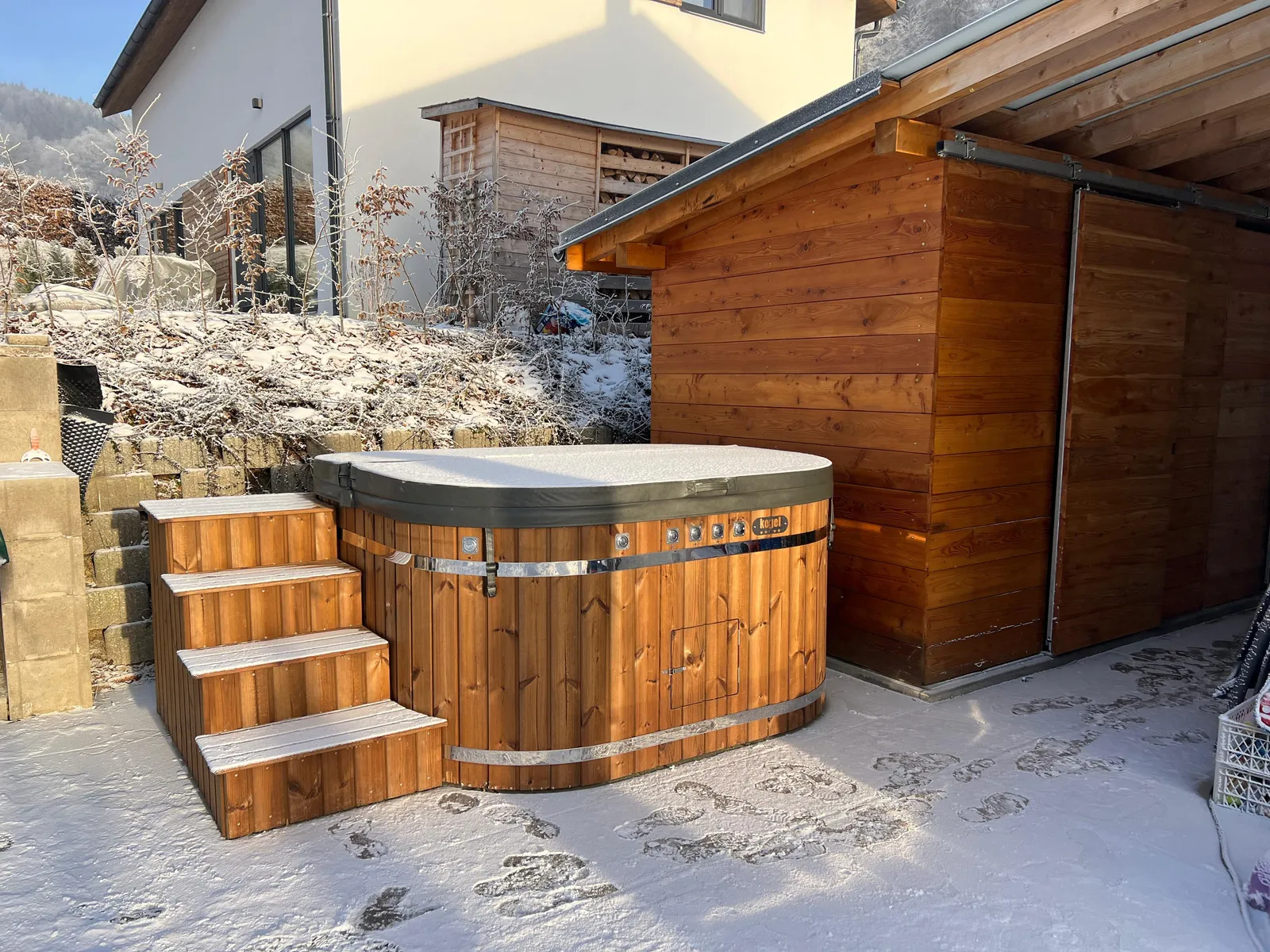 Wooden hot tub on the snow-covered terrace
